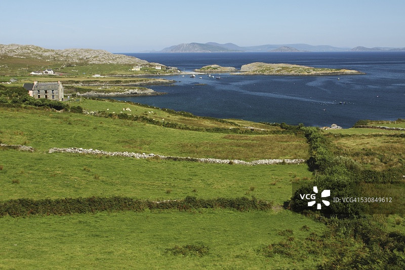 爱尔兰科克郡比拉半岛海岸线的绿色田野和小型农舍图片素材