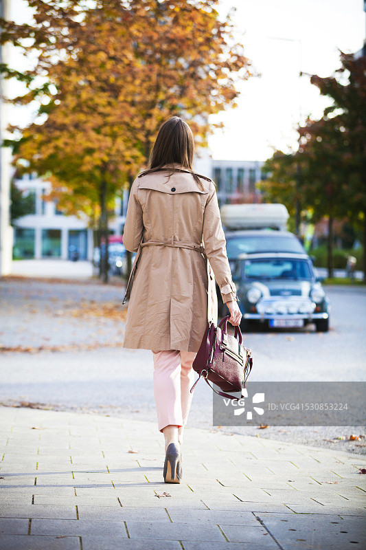 年轻女子在德国巴伐利亚慕尼黑的人行道上行走图片素材