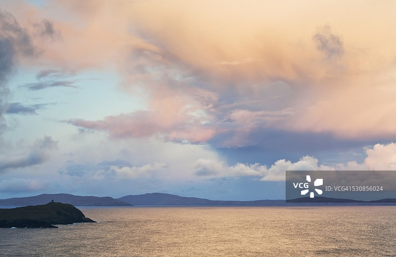 日落时分在爱尔兰科克郡贝拉半岛水面上反射的发光云彩图片素材
