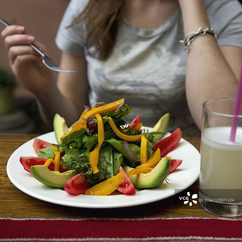 在秘鲁库斯科，一位年轻女子在吃沙拉图片素材