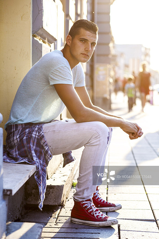 坐在人行道上的年轻男人图片素材