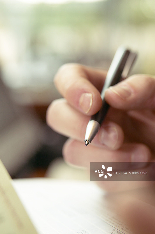 手持钢笔的女子特写图片素材