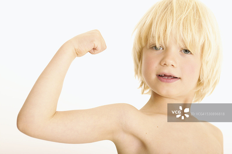 男孩自豪地展示手臂肌肉图片素材