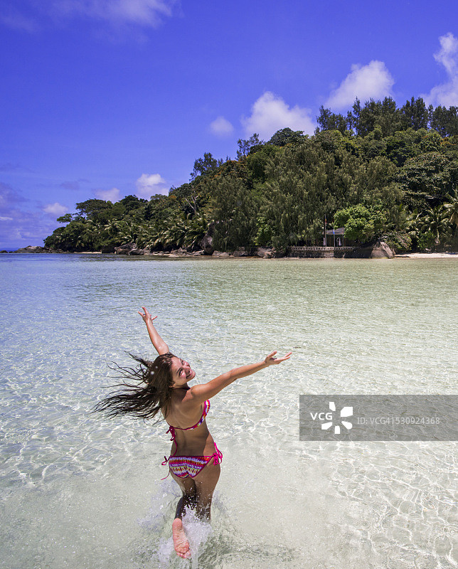 在塞舌尔海边奔跑的无忧无虑的女人俯视图图片素材