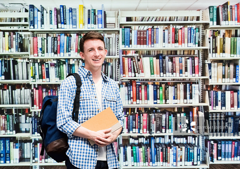 微笑的学生在图书馆看书图片素材