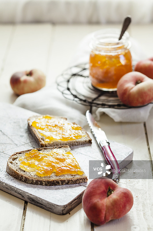 两片棕色面包和甜甜圈桃子上的桃子酱图片素材
