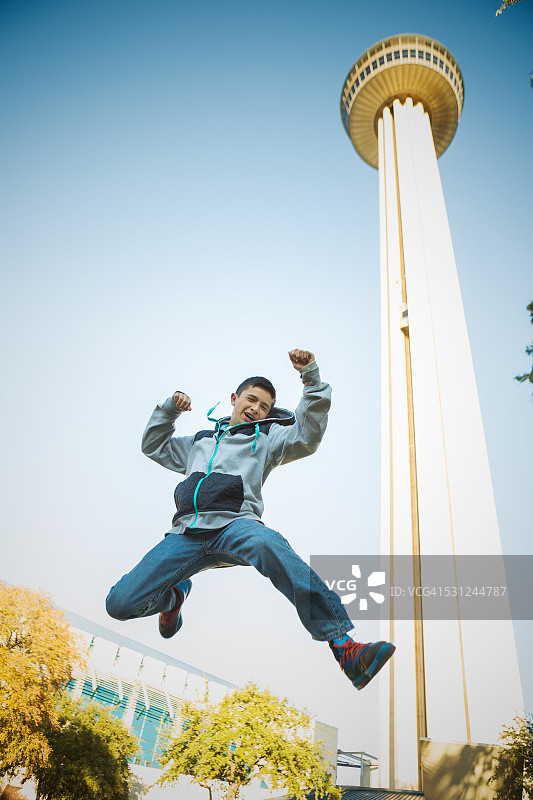 在塔前跳跃的男孩图片素材