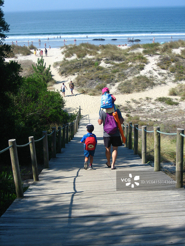 父亲带着两个儿子去海滩图片素材