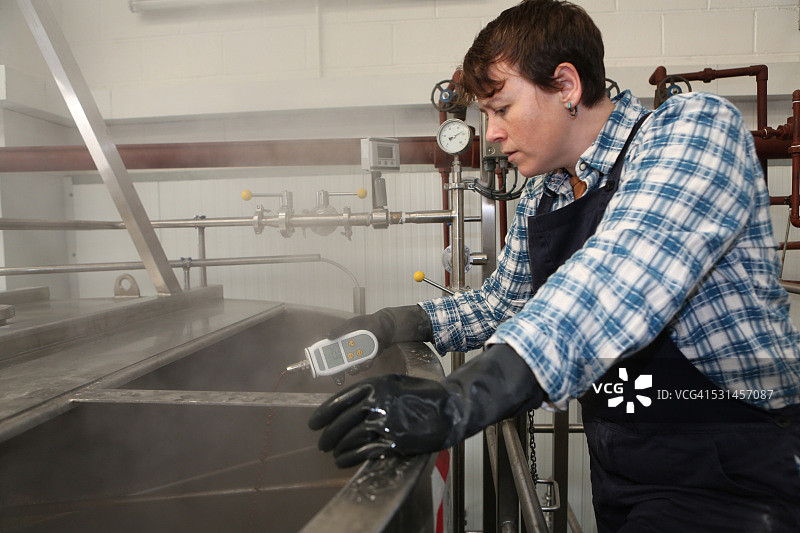 女酿酒师正在测试罐内温度图片素材