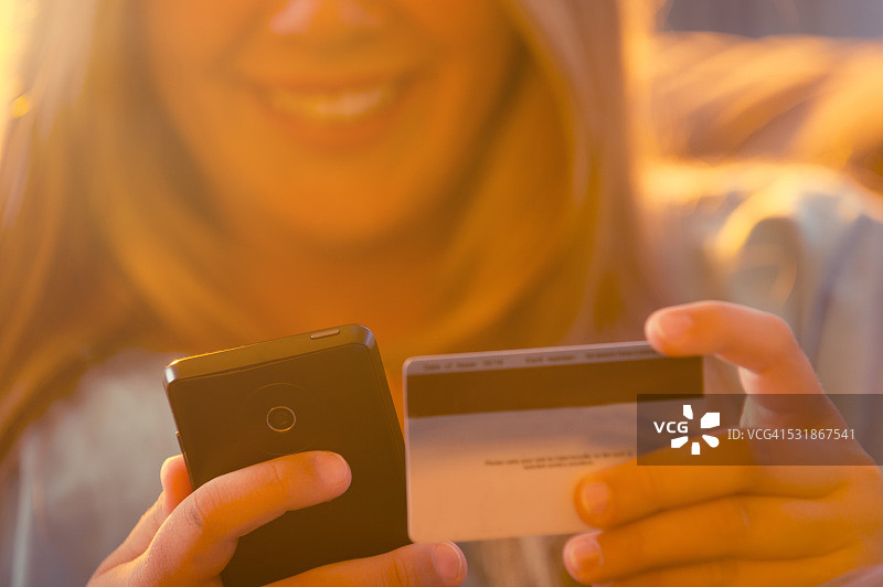 用手机和信用卡购物的年轻女孩图片素材