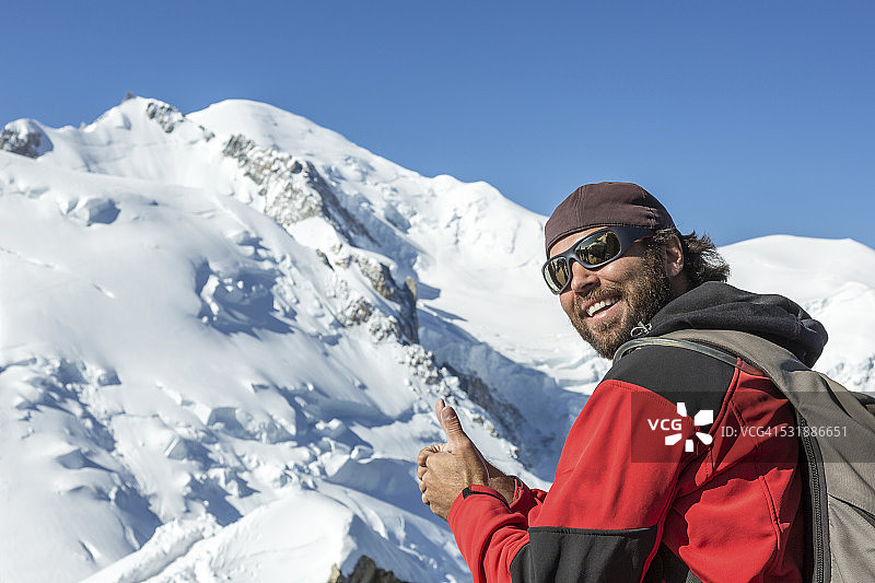 在法国勃朗峰峰顶竖起大拇指的男人图片素材