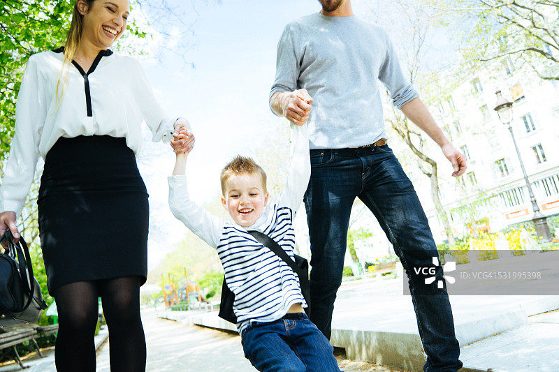 幸福家庭送儿子上学穿过公园图片素材