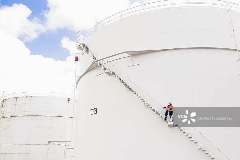 站在燃料储罐楼梯上的白人技术员图片素材