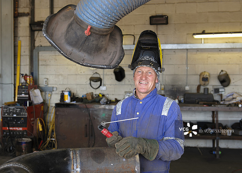车间里微笑的白人焊工图片素材