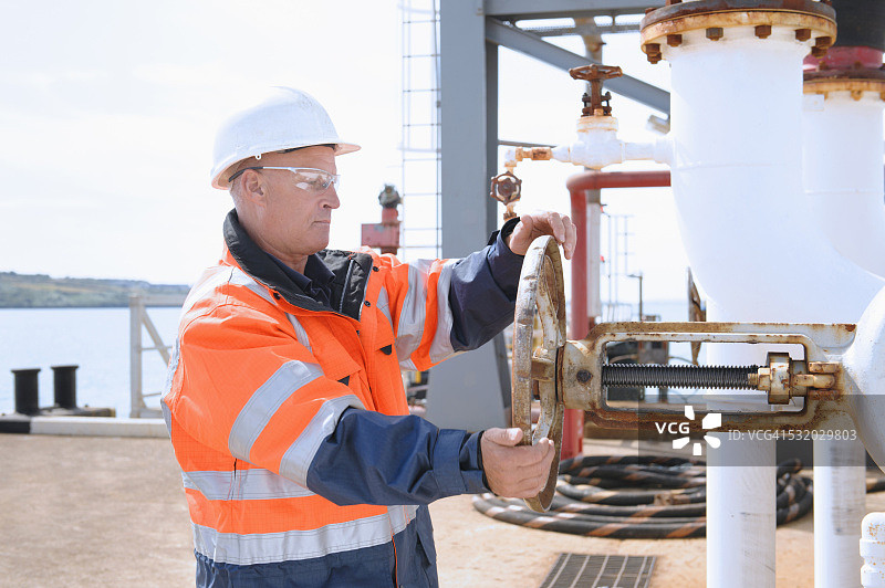 正在检查机器上仪表的白人技术员图片素材