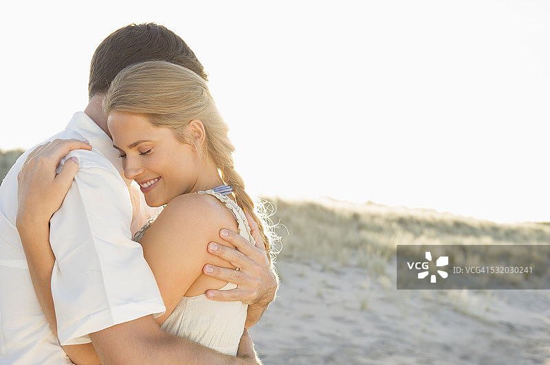 白人情侣在海滩上拥抱图片素材