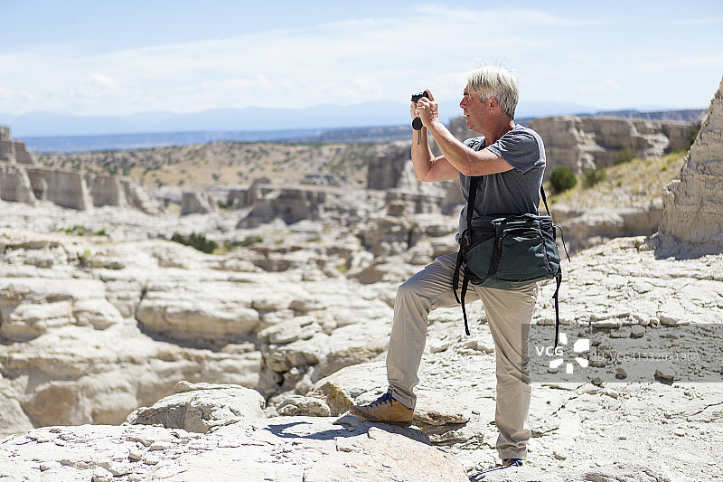 年长的白人男子在新墨西哥州阿比丘拍摄岩层图片素材