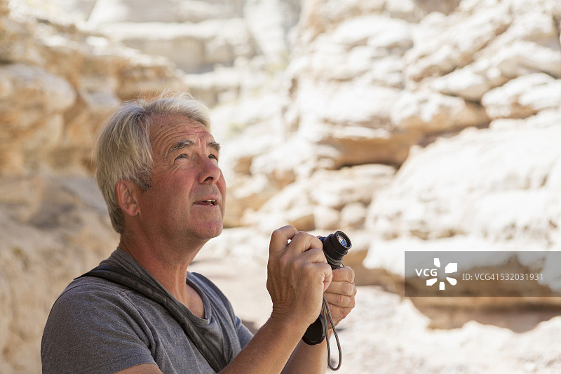 拍摄岩石构造的年长的白人男子图片素材