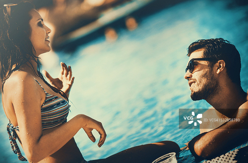 在游泳池边放松的两人图片素材