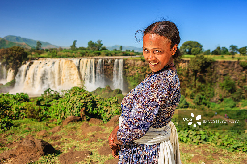 在蓝色尼罗河瀑布的快乐埃塞俄比亚妇女图片素材