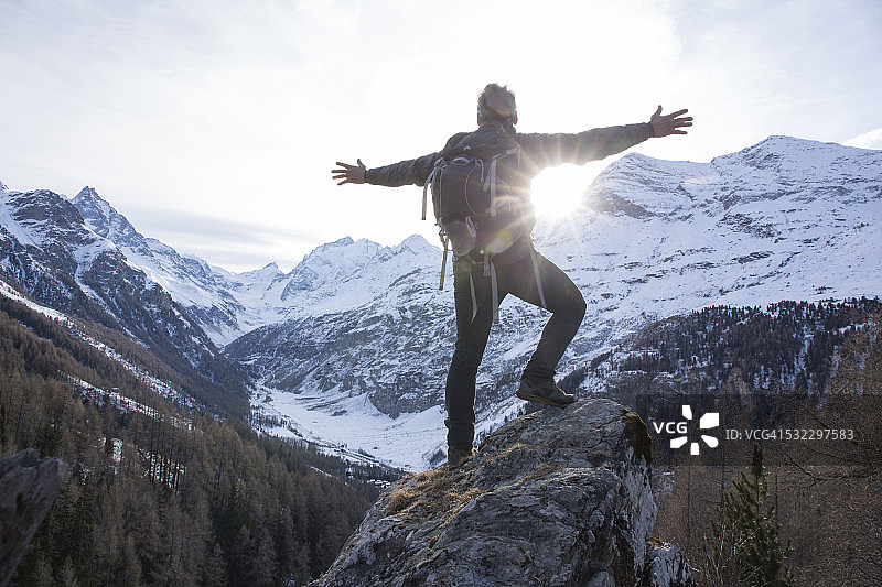 徒步者在日出时伸开双臂，拥抱群山图片素材