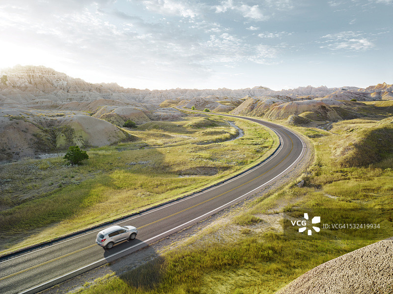 SUV行驶在恶地国家公园的壮丽景色中图片素材
