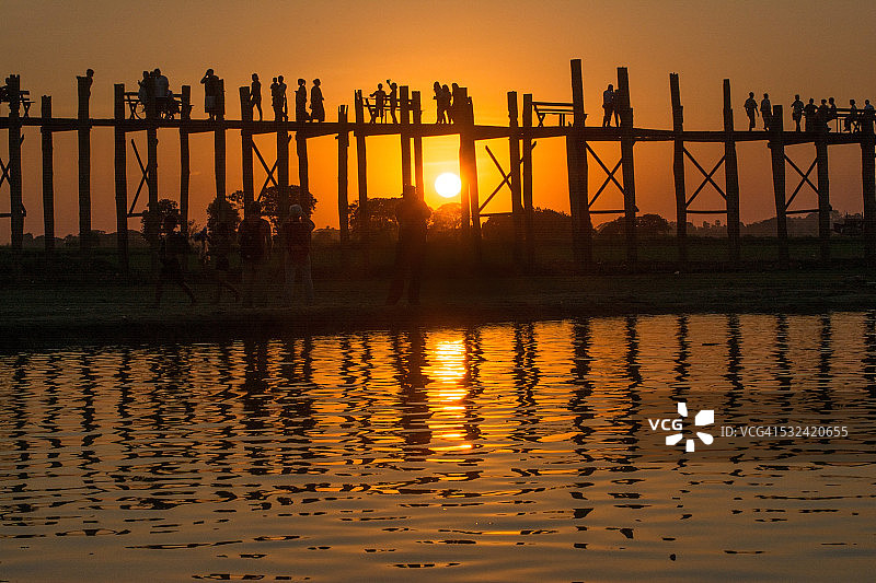 日落时分在乌本桥上的人们，曼德勒，缅甸图片素材