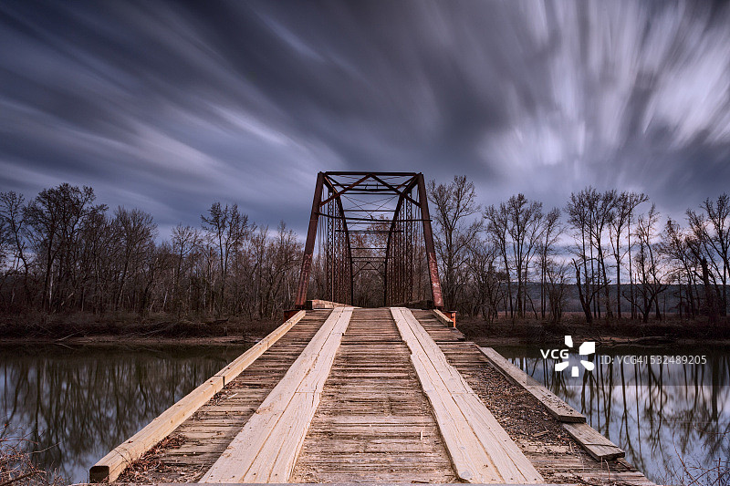 暴风雨天气的河流上的旧铁桥图片素材