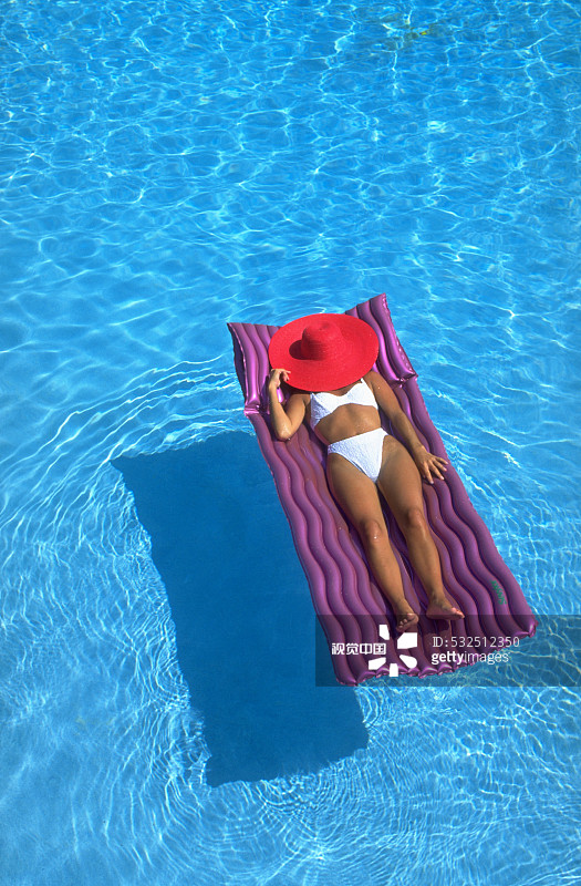在泳池里享受日光浴的女子图片素材