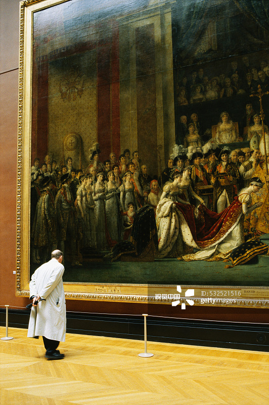 男人观看雅克-路易·大卫的《拿破仑一世加冕大典》图片素材