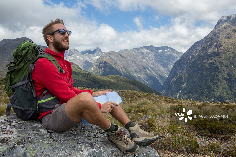 年轻的徒步旅行者在地图上寻找正确的路线图片素材