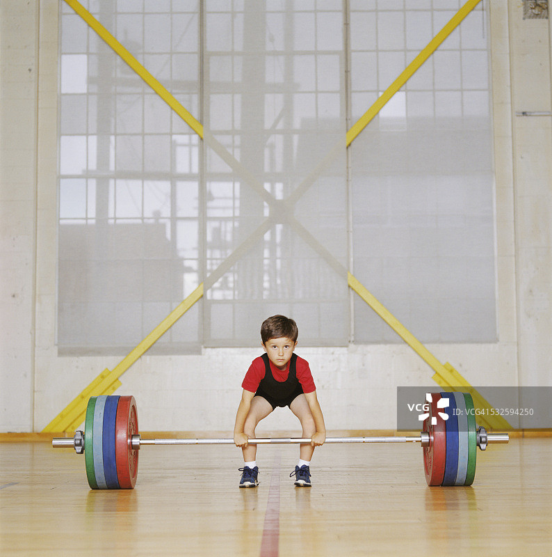 男孩准备举起杠铃和哑铃图片素材
