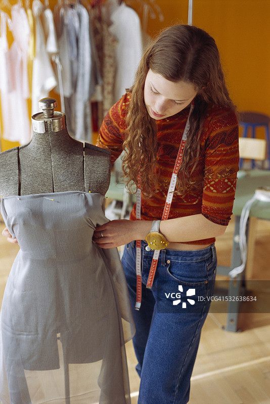 女裁缝在人体模型上调整面料图片素材