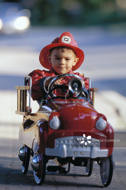 男孩驾驶玩具消防车图片素材