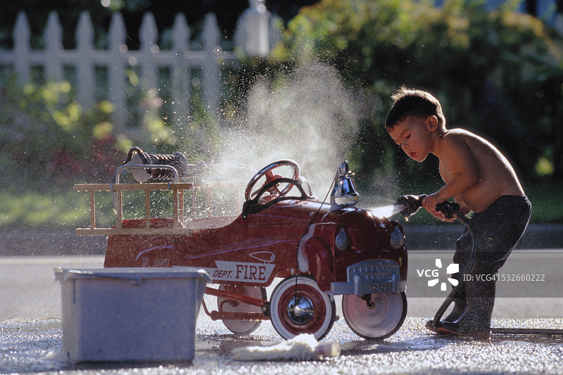 男孩清洗玩具消防车图片素材