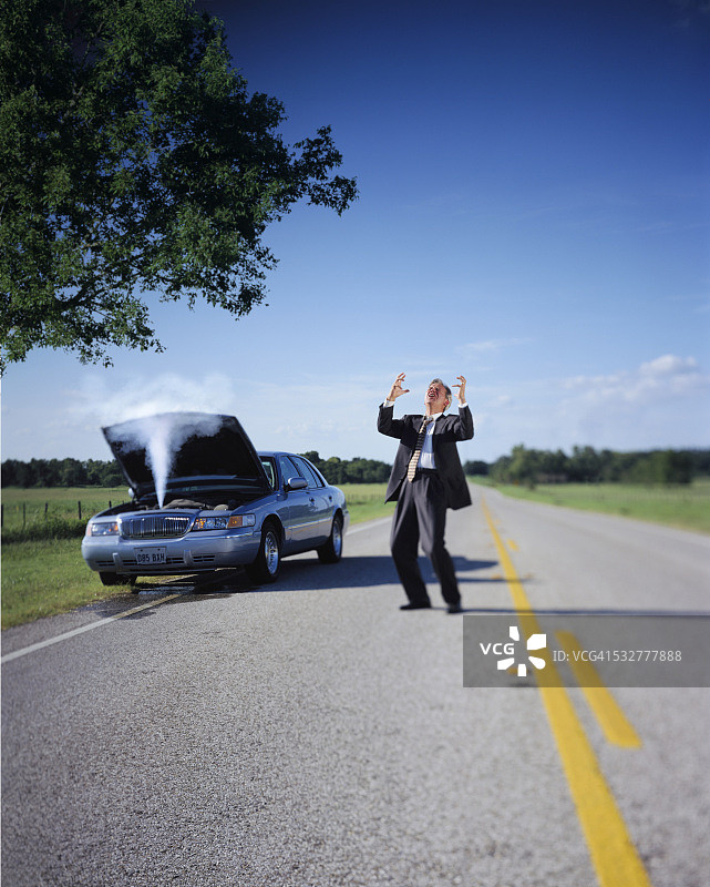 对着过热的汽车大喊大叫的商人图片素材