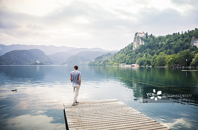男人在码头上欣赏湖景（斯洛文尼亚布莱德湖）图片素材