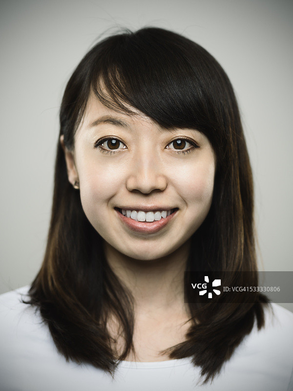 看着镜头的快乐年轻日本女人肖像图片素材