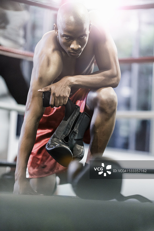 自信的拳击手在拳击台上拿着运动手套图片素材