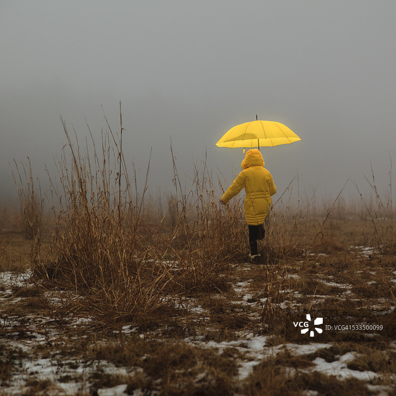 薄雾中穿过田野的小女孩图片素材