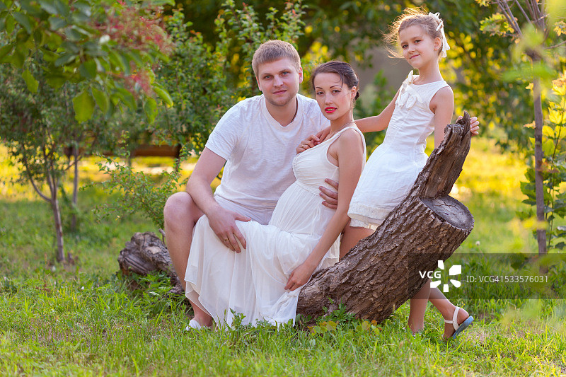 一家人坐在花园的圆木上图片素材