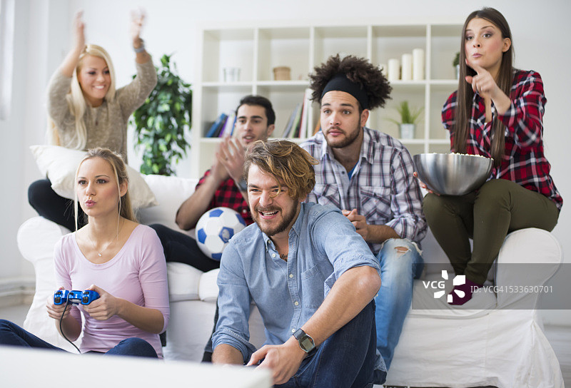 快乐的年轻朋友玩电子游戏图片素材