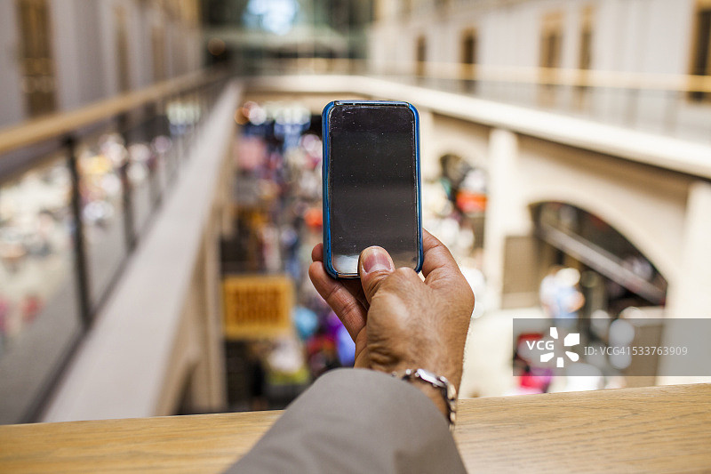 在高处用手机拍照的西班牙裔商人图片素材