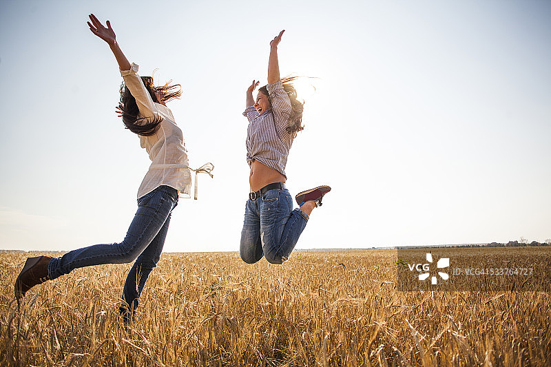 在乡村田野里欢乐跳跃的白人女性图片素材