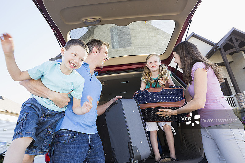 白人家庭从车里取出旅行箱图片素材