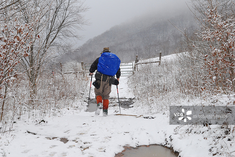 男人在雪地里用登山杖徒步旅行图片素材