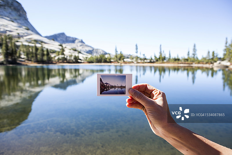 女人拿着一张宝丽来照片图片素材