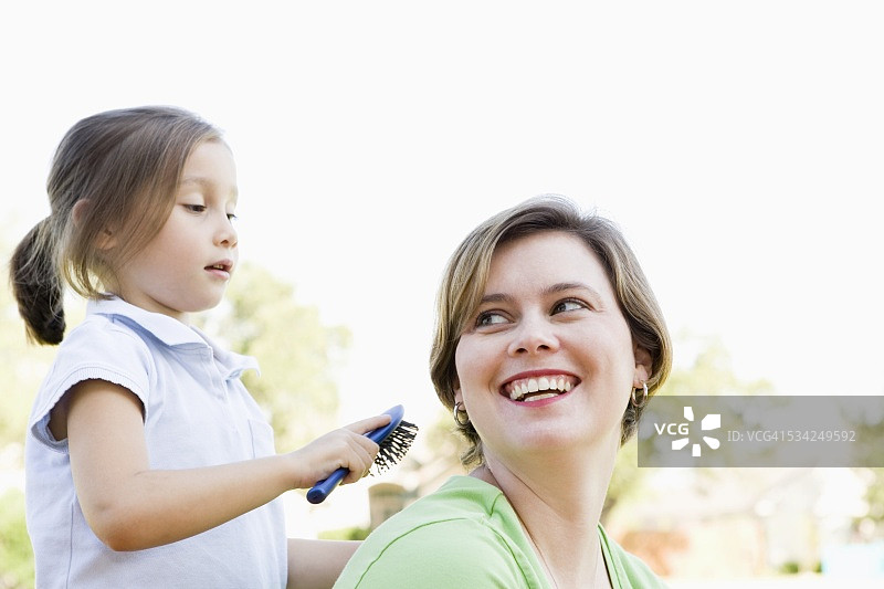 女孩梳理母亲的头发图片素材