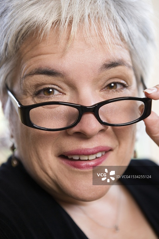女人从眼镜上方看过来图片素材
