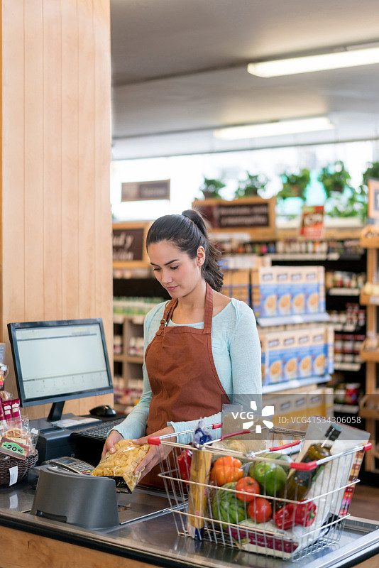 在杂货店工作的收银员图片素材